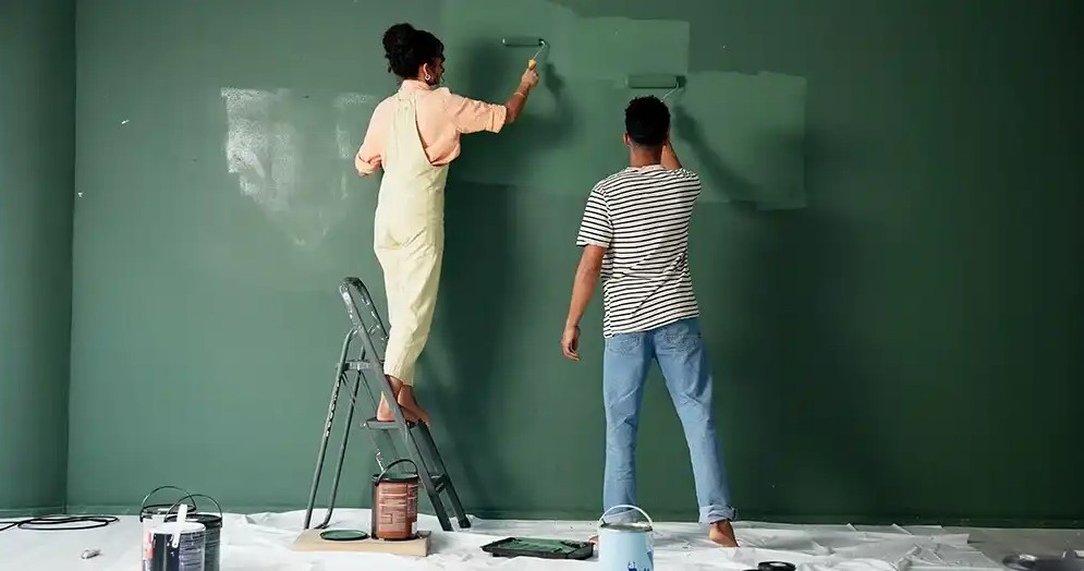 A couple painting their house