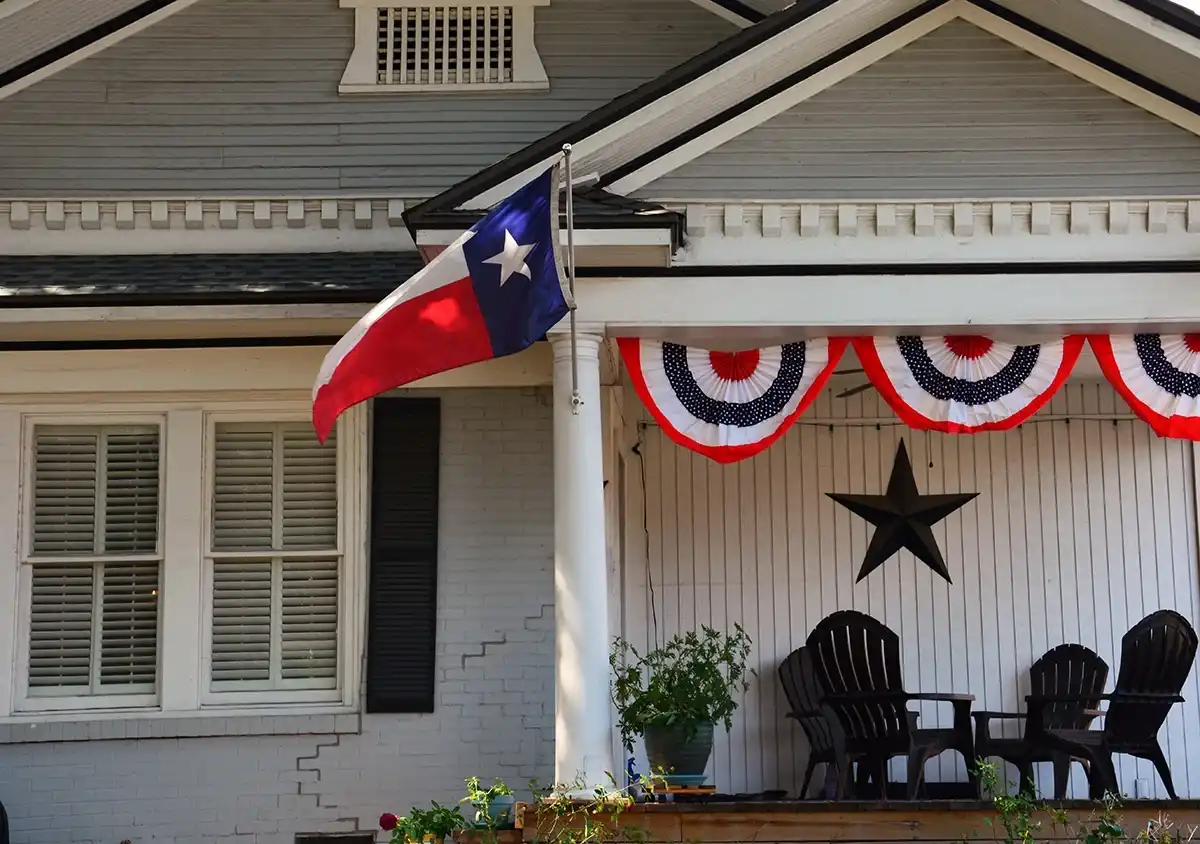 Texas flag flying on the front porch of a house