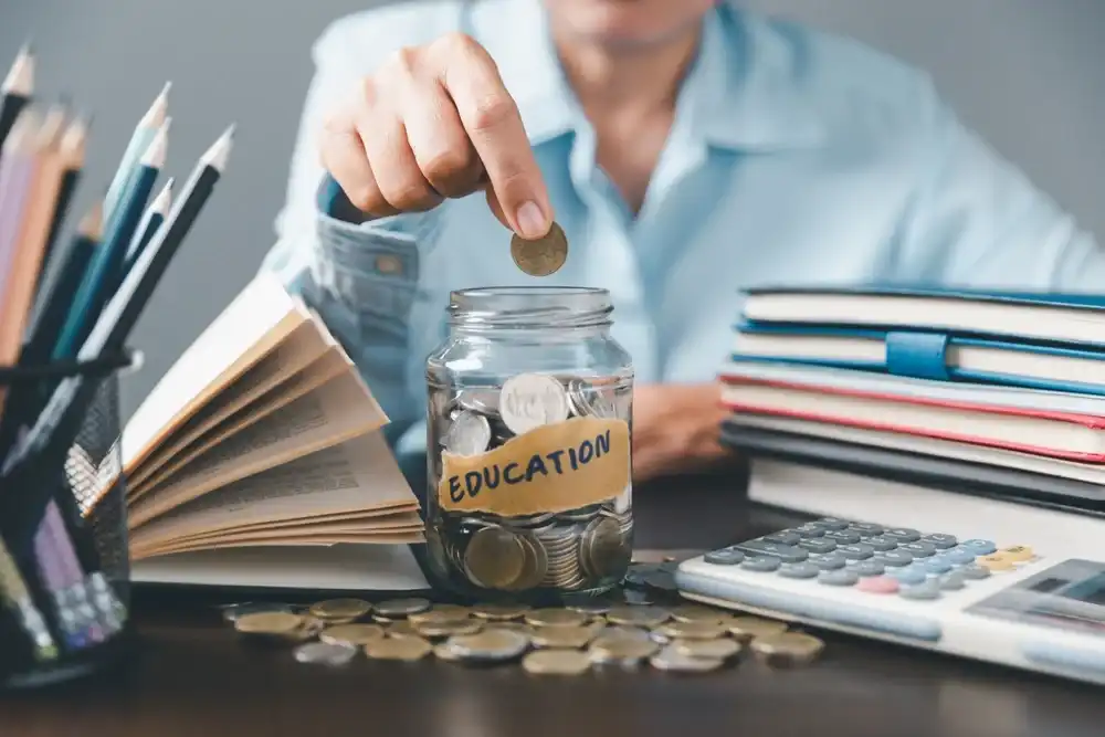 Someone deposting a coin in a jar labeled "Education"