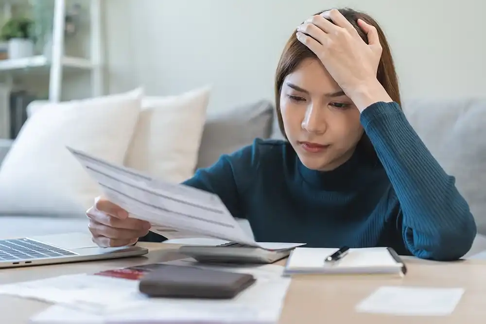 Woman looking over payday loan bills