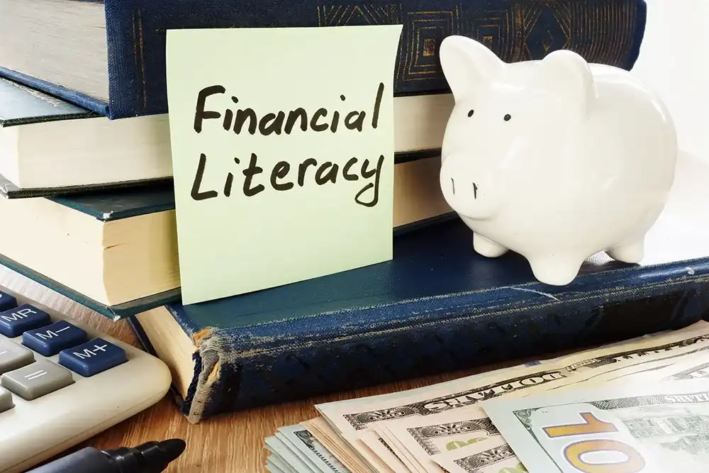 A postcard that reads "Financial Literacy" on books next to a piggy bank