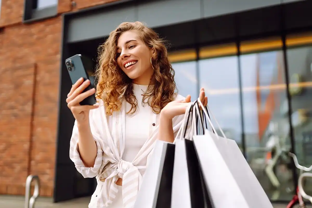 Woman checking her phone after shopping in a store